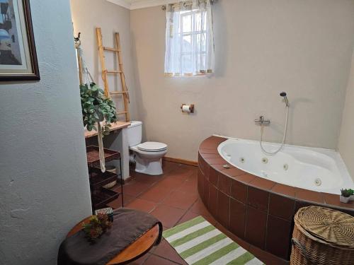 a bathroom with a bath tub and a toilet at Barnfires Farmhouse in Denysville