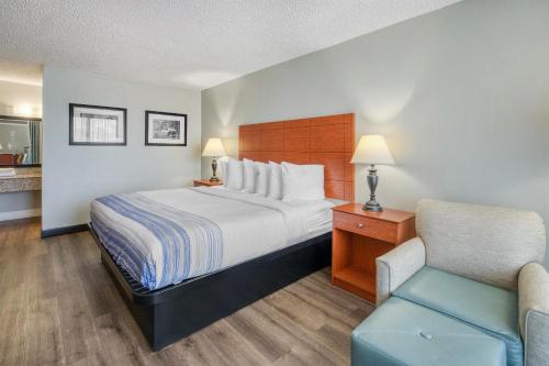 a hotel room with a bed and a chair at Best Western Fredericksburg in Fredericksburg
