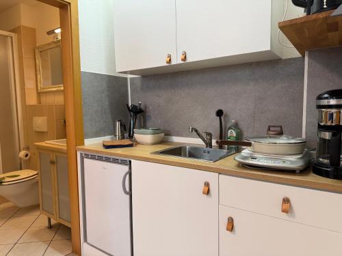 a kitchen with white cabinets and a sink at Hygge Cabin in Rostock