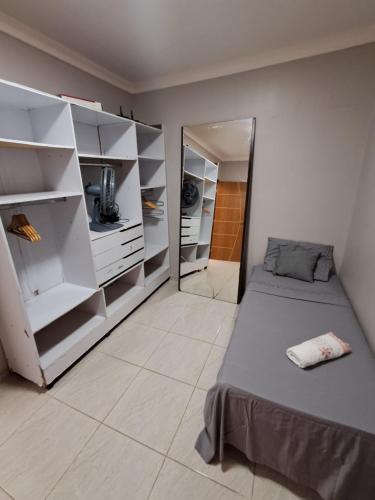 a bedroom with a bed and shelves and a mirror at Conexão Cariri in Juazeiro do Norte