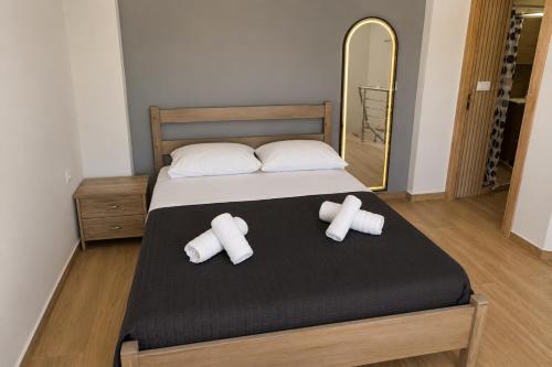 a bedroom with a bed with two pillows and a mirror at Karies House in Kefalos
