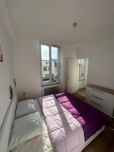 a bedroom with a bed and a dresser and two windows at De passage in Nemours