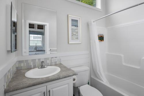 a white bathroom with a sink and a toilet at Jellystone Park TM Petoskey in Petoskey