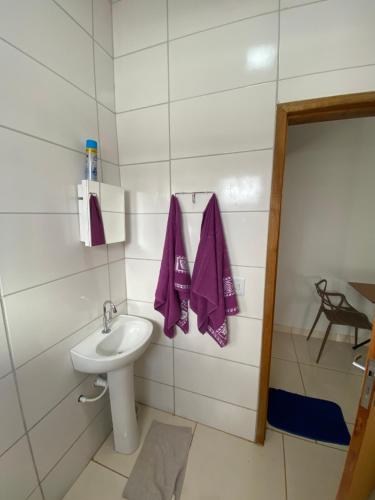 a bathroom with a sink and a purple towel at Flat aconchegante é silencioso in Rio Verde