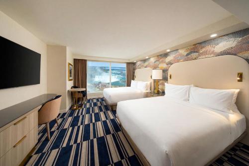 a hotel room with two beds and a flat screen tv at Hyatt Regency Niagara Falls Fallsview in Niagara Falls
