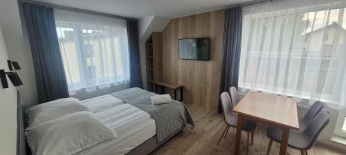 a bedroom with a bed and a table and a window at Willa Wladek in Władysławowo