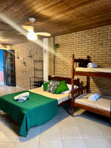 a bedroom with two bunk beds with a green table at Flats na praia de Trindade Paraty flats nazar in Paraty