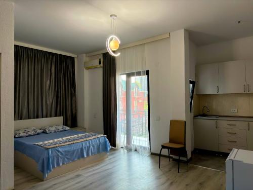 a bedroom with a bed and a kitchen with a window at Hotel Palm Gonio in Kvariati