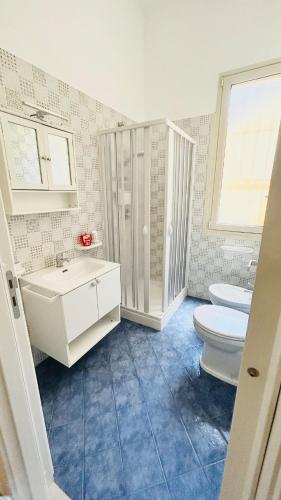 a white bathroom with a toilet and a sink at Casa Luna in Paceco