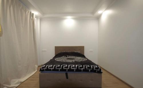 a bed in a room with a white wall at ST Luxury Apartment Riga in Riga