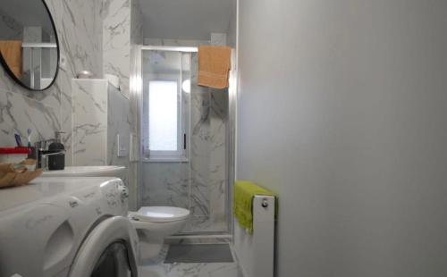 a white bathroom with a toilet and a shower at ST Luxury Apartment Riga in Riga
