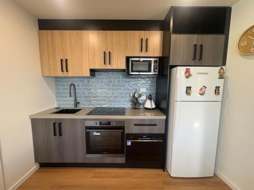 a kitchen with a white refrigerator and a microwave at Derwent Waters Hideway in Austins Ferry
