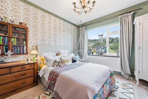 a bedroom with a bed and a dresser and a window at Hillsley House in Wirksworth