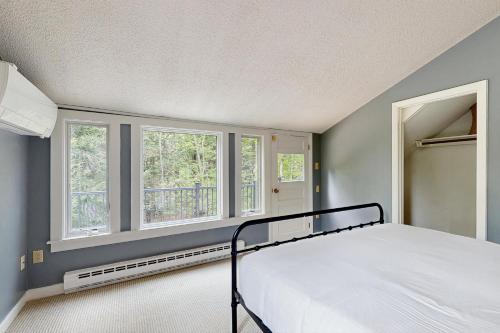 a bedroom with a bed and two windows at Quechee's Cloud 9 in Hartford