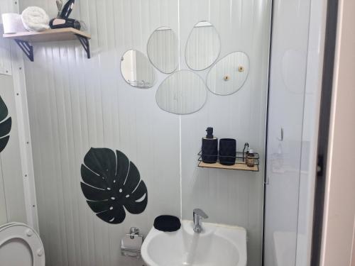 a white bathroom with a sink and a toilet at Bungalows Rea in Burgas