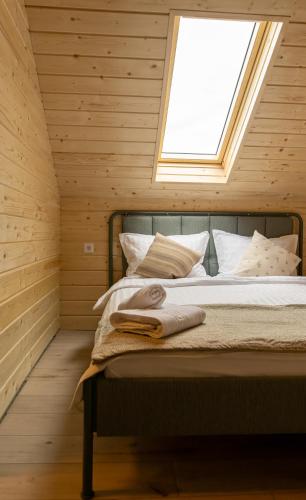 a bed in a wooden room with a window at Meștera 9 in Stînceni