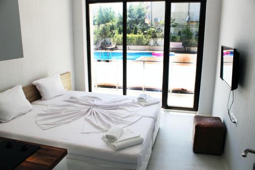 a bedroom with a white bed with a large window at Stamopolu Lux ground floor in Primorsko