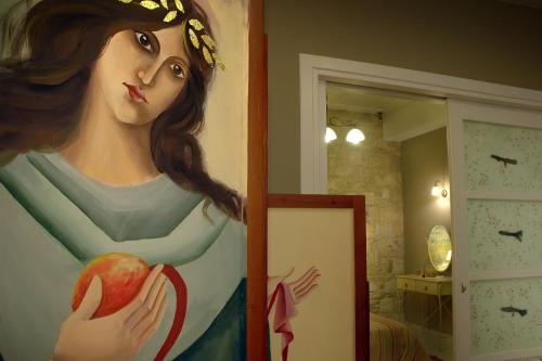 a painting of a woman holding an apple at Katalagari Country Suites in Archanes