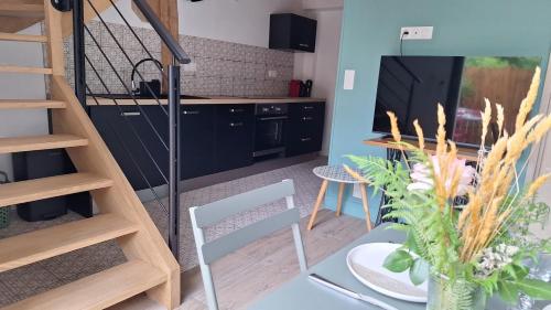 a kitchen with a table with a vase of flowers at Villa Annabelle "Azur" appartement de charme entre océan et forêt à Messanges in Messanges