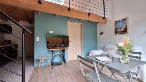 a dining room and kitchen with a table and chairs at Villa Annabelle "Azur" appartement de charme entre océan et forêt à Messanges in Messanges