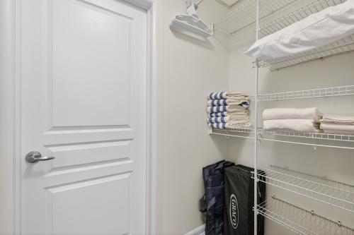 a closet with a white door and towels at Luxury Playa Del Sol Condo 435 w Pool, Hot Tub & Beach Nearby in Kelowna