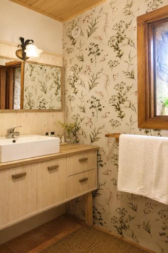 a bathroom with a sink and floral wallpaper at LA CUMBRE-Calma, Desconexión y Piscinas Naturales en Sierra de Gata TR-CC-00490 in Gata