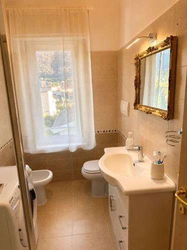 a bathroom with a sink and a toilet and a window at il canto del lago in Iseo