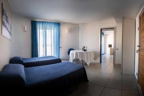 a living room with a table and a couch and a room at Hotel Kore in Villaggio Mosè