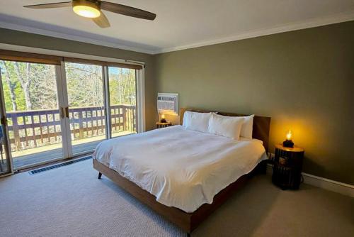 a bedroom with a large bed and a balcony at Partridge Hill House in Hartford