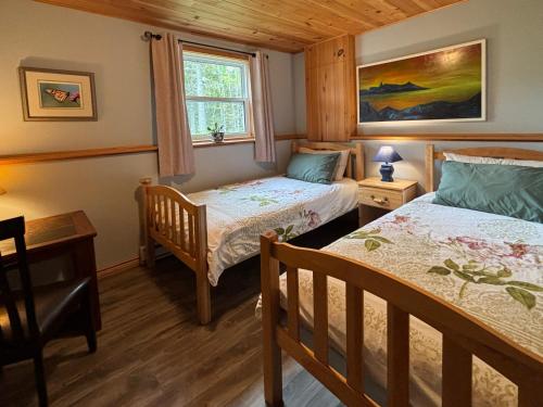 a bedroom with two beds and a window at Sunrise Place Bed & Breakfast in DʼEscousse
