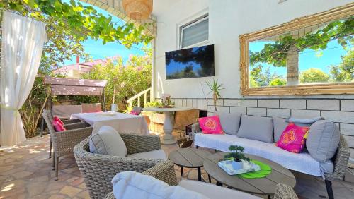 a patio with a couch and tables and a mirror at Avalena Residence in Zadar