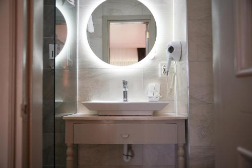 a bathroom with a sink and a mirror at Albeon Luxury Hotel - Alacatı in Alaçatı