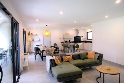 a living room with a couch and a dining room at Spacious house with garden in Soustons