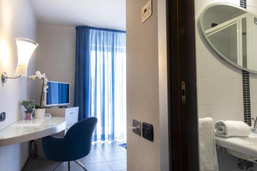 a bathroom with a desk and a chair and a mirror at Hotel Kore in Villaggio Mosè