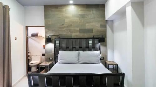 ein Schlafzimmer mit einem schwarzen Bett und ein Badezimmer in der Unterkunft Los Diques in Agua Dulce