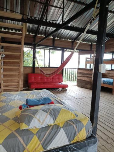 a bed and a hammock in a room at Cabaña la fundadora in San Luis