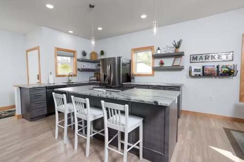a kitchen with a large counter with four chairs at Maison Rouge by Simple Life Rentals in Luxemburg