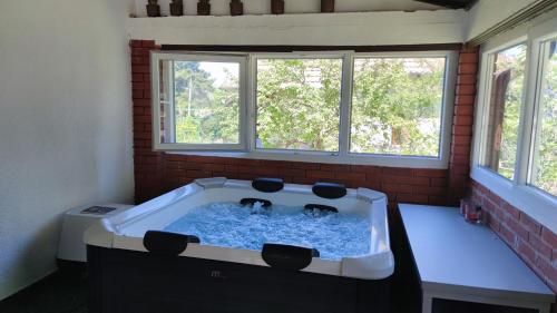 a hot tub in a room with two windows at Konak Jugovo in Smederevo