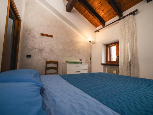 a bedroom with a blue bed and a window at Al centro e vicina al lago in Farra dʼAlpago