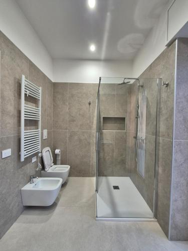 a bathroom with a shower and a toilet and a sink at Mirabaia in Bacoli