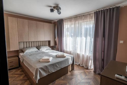 a bedroom with a bed with two towels on it at V&G Apartments in Kyustendil
