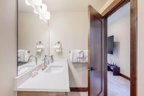 a bathroom with a sink and a large mirror at A Slice of Silverthorne in Silverthorne