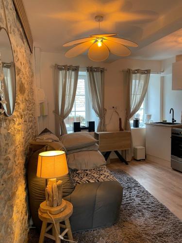 a living room with two beds and a table with a lamp at Studio de caractère en pierre in Coutances