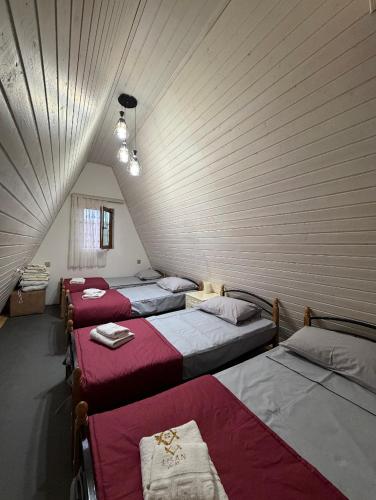 a group of four beds in a room at Lisan VIllas in Nabran