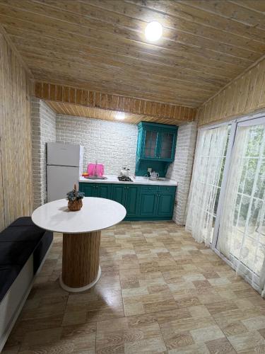 a kitchen with a white table and a refrigerator at Lisan VIllas in Nabran