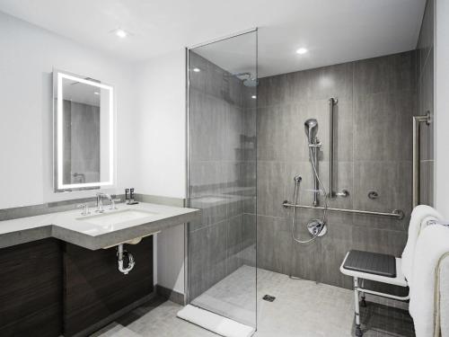 a bathroom with a sink and a glass shower at Novotel Montreal Center in Montreal