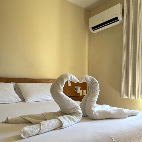 a pair of towels forming a heart on a bed at Vilamar Suítes in Aquiraz