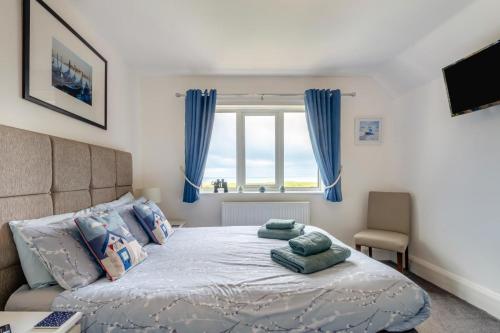 a bedroom with a bed with blue curtains and a window at 1 Bed in Filey oc-77710 in Hunmanby