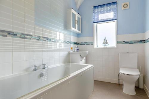 a bathroom with a tub and a toilet and a sink at 1 Bed in Filey oc-77710 in Hunmanby