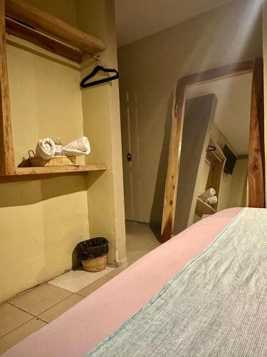 a corner of a room with a bed and a shelf at Hotel Portal & Suites in Ciudad Hidalgo